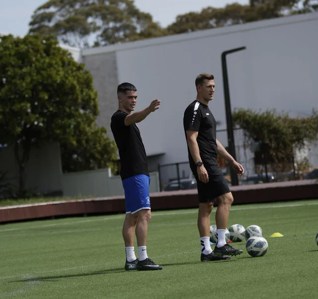 Coach Jan and a player on a football pitch